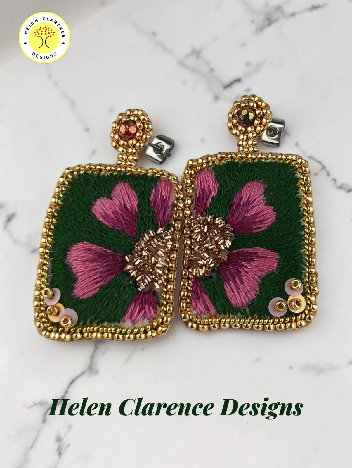 Boucles d'oreilles : Boucles d’oreilles rectangulaires uniques, brodées en soie et représentant une fleur rose sur fond vert foncé.